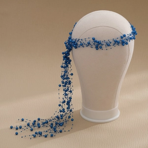 Detail of handmade deep blue pearl tassel hair accessory on a white model head