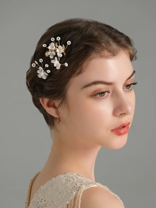 Detail of handmade white flower hair pins with gold wire and pearls for bridal hairstyles