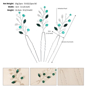 Macro detail of handmade U-shaped hair pins with green gems and white pearls on silver wire