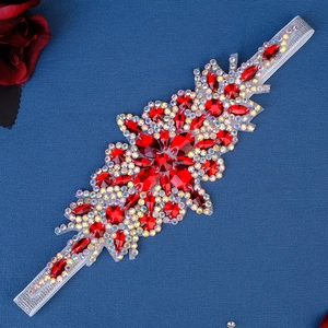 Détail d'un bandeau de mariée avec strass rouges faits main et cristaux étincelants