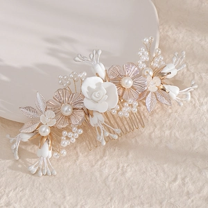 Peigne à cheveux de mariée avec fleurs en céramique blanches et perles sur feuilles dorées