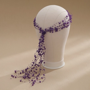 Detail of elegant handmade purple pearl tassel headband with beaded fringe on white mannequin