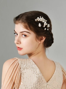 Detail of elegant pearl hair comb set with floral accents on a bridal hairstyle