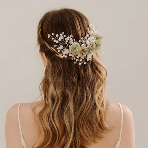 Detail of handmade bridal hairpiece with green fabric flowers, pearls, and crystals