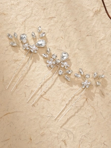 Detail of three bridal hair pins with white pearls and crystals in floral design
