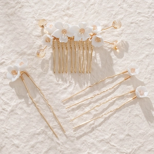 Detailed close-up of handmade bridal hair comb set with white flowers and pearls