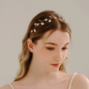Detail eines Braut-Haarbands mit goldenen Blättern und weißen Perlen am Model getragen