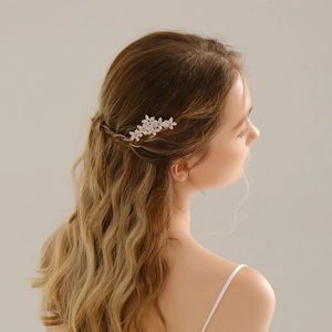 Detail view of crystal zircon flower hair comb on a bride's elegant updo hairstyle