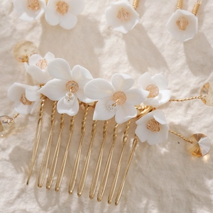 Close-up of handmade pearl bridal hair comb with gold wire and floral details