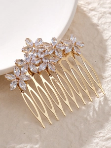 Macro detail of bridal hair comb with gold metal teeth and sparkling zircon flowers