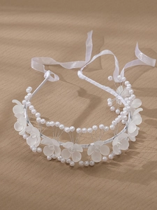Détail de serre-tête mariage avec fleurs acryliques givrées et perles sur rubans blancs