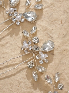 Detailed close-up of handmade bridal hair pin with crystal flowers and white pearls