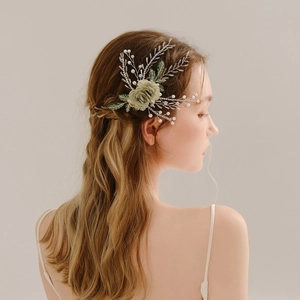 Detailed close-up of handmade green flower bridal hairpiece with pearls and crystals