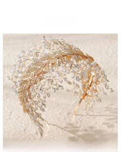 Macro shot of bridal headband featuring gold metal leaves, white pearls and crystals