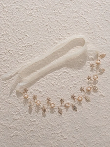 Detail eines goldenen Brautstirnbands mit Perlen, Metallblättern und Seesternen