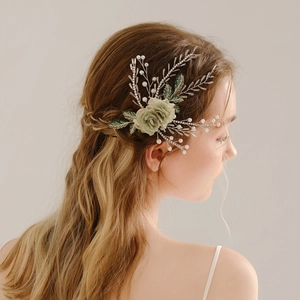 Detail of handmade bridal hairpiece with green roses, pearls and crystals on hair