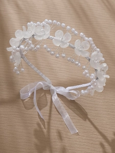 Vue détaillée du serre-tête de mariée avec fleurs en acrylique et perles sur ruban satin