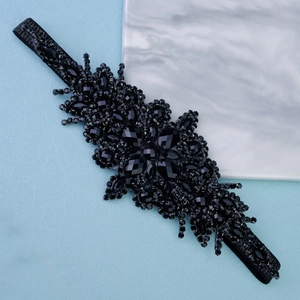 Gros plan détaillé sur les perles de cristal noir cousues main d'un bandeau élastique de luxe