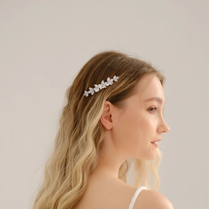Detailed side view of silver leaf-shaped bridal hair comb set with sparkling zircon stones