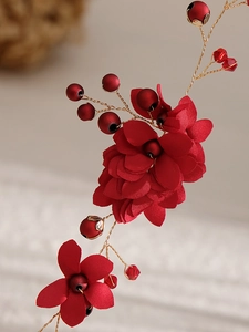 Détail d'un bandeau de mariée fait main avec fleurs rouges en tissu, cristaux et fil doré