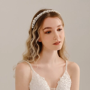 Detail of delicate white ceramic flowers and beadwork on a bridal headband accessory
