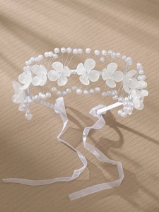 Détails de fleurs en acrylique blanc et perles sur un bandeau de mariée avec rubans