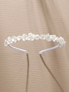 Close-up of white ceramic flowers and sparkling rhinestones on the elegant bridal headband