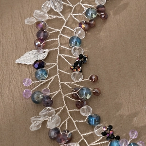 Macro shot of silver crystal bridal hairband with purple beads and metal leaves