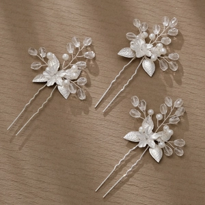 Detailed view of silver bridal hair pins with pearls and crystal beads for weddings