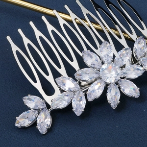 Detail of silver bridal hair comb with marquise zircons on deep blue background