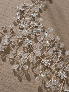 Détail d'une vigne de cheveux de mariée avec perles en argent et fleurs en strass