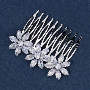 Detail of silver hair comb featuring three flower motifs and sparkling cubic zirconia