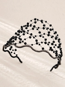 Close-up of black beaded crown headband with sparkling rhinestones and woven texture