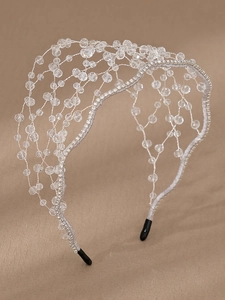 Detail of silver woven headband with crystal beads and rhinestones on leather background