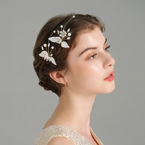Detail of handmade bridal hair pins with white flowers and pearls for wedding hairstyles