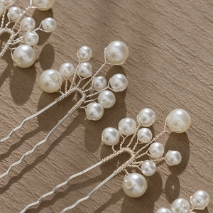 Detail of handcrafted pearl hair pin with silver wire floral structure for bridal styling