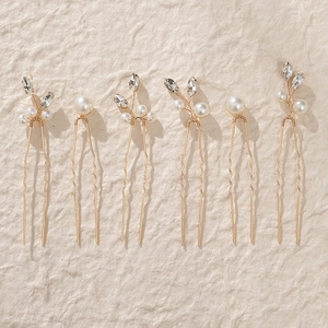 Detail of 6-piece handmade gold bridal hair pins with white pearls and marquise rhinestones