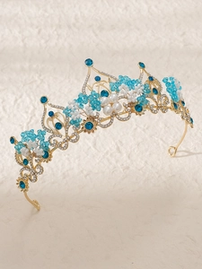 Detailed close-up of Baroque gold crown with blue crystals and handmade pearl beads