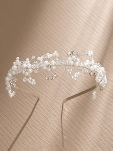 Détail d'un serre-tête de mariée artisanal avec perles et cristaux sur fil argenté