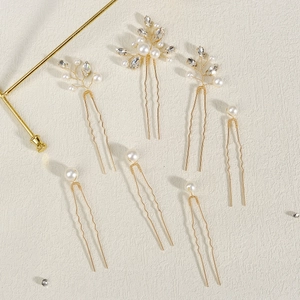 Macro detail of 6-piece gold bridal hair pin set with white pearls and crystals
