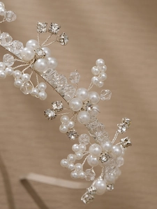 Détails d'un serre-tête de mariée fait main avec fil d'argent, perles et cristaux