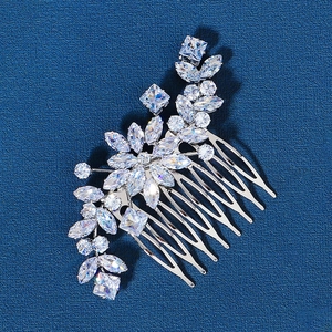 Close-up of bridal hair comb with marquise zircons and floral leaf design on blue background