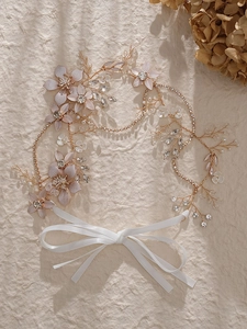 Détail d'un bandeau de mariée fait main avec fleurs en cristal et rubans en soie blanche