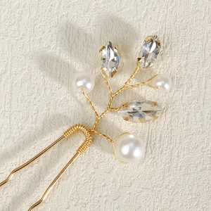 Detail of handmade bridal hair pin with gold wire branches, pearls and marquise rhinestones