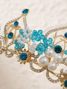 Detail of golden bridal crown with blue gemstones, crystals and handcrafted pearls