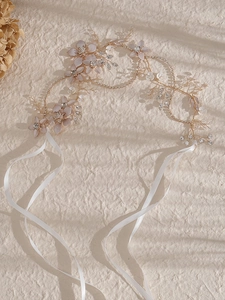 Détail d'un bandeau de mariée fait main avec fleurs en tissu rose, perles et cristaux