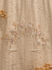 Close-up of handmade bridal hair vine with silver leaves, pink rhinestones and pearls