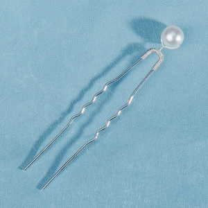 Detail of U-shaped hairpin featuring a white pearl secured with silver wire wrapping