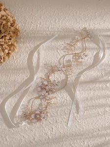 Détail d'un serre-tête de mariée fait main avec fleurs en tissu rose, perles et cristaux