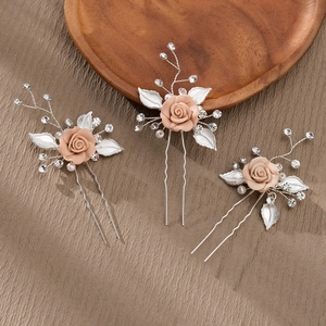 Detailed close-up of handmade bridal hair pins featuring pink resin roses and pearls